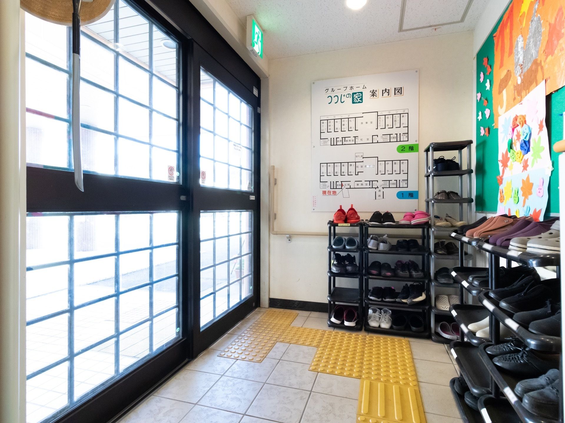 透明な窓上の自動ドアからは外の光が差し込み柔らかな空間になっている。土足用の棚が用意されていおりきちんと整理されている。