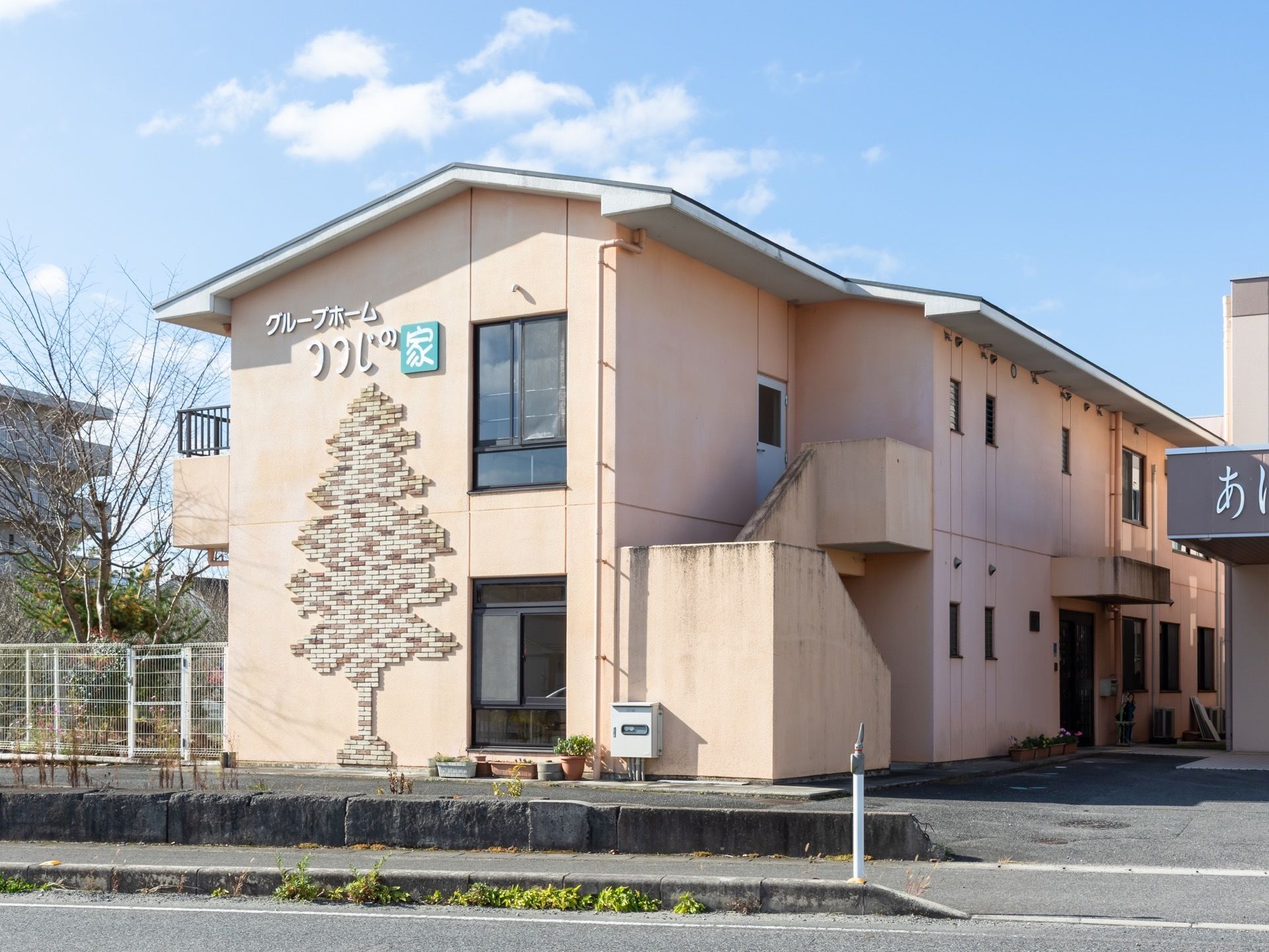 肌色を基調とした２階建ての施設で、正面の壁にはレンガを張り合わせて木を表現したオシャレなデザインが施されている。