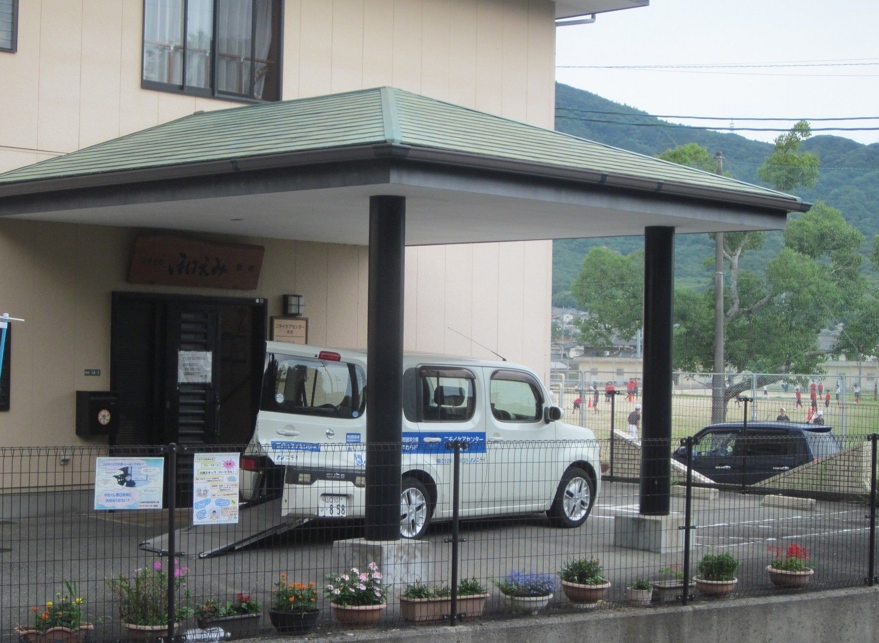 入口と車両のある施設外観