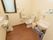 手洗い場と洋式の便器、掃除用シンクが設置された広いトイレの個室。壁には各種の手すりや、緊急呼出しボタンなどが備え付けられている。