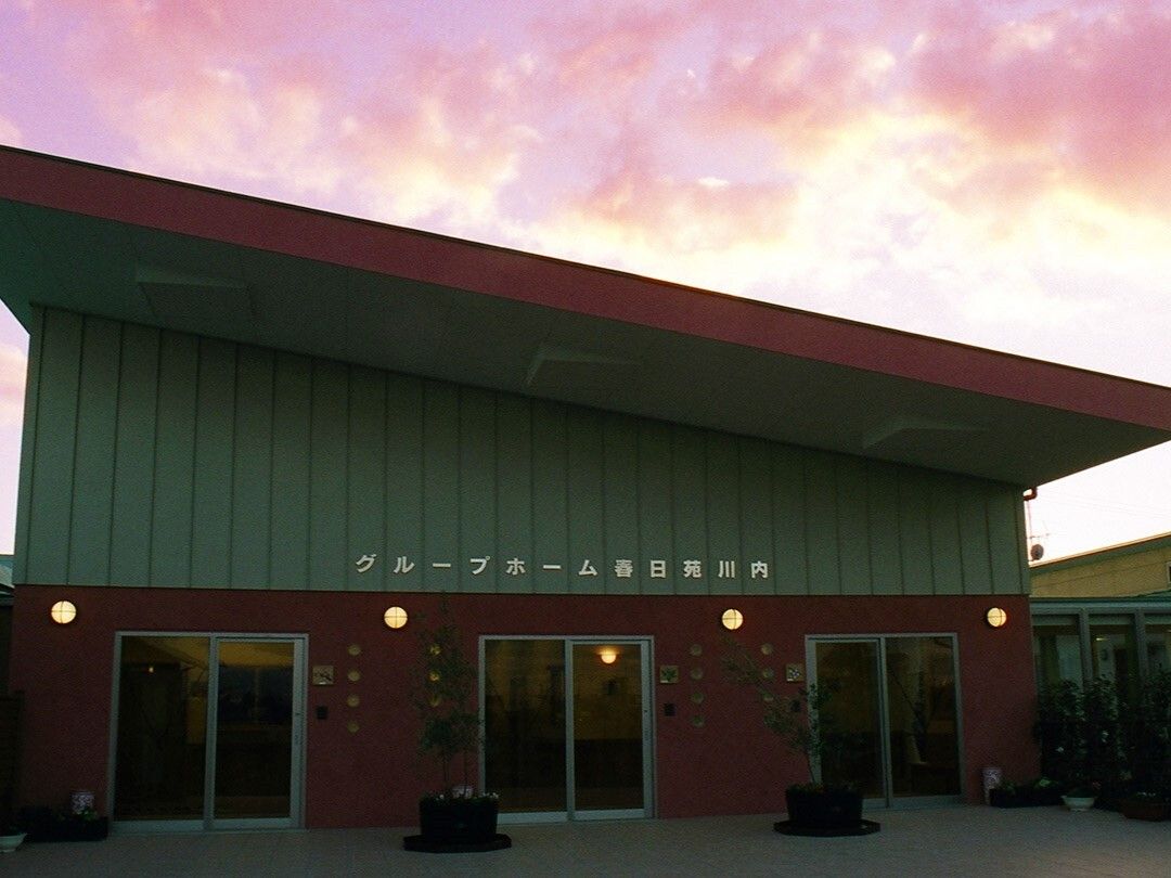 斜めに設置された屋根が印象的な建物の外壁にはホーム名が書かれていて、大きな窓が複数付いている。