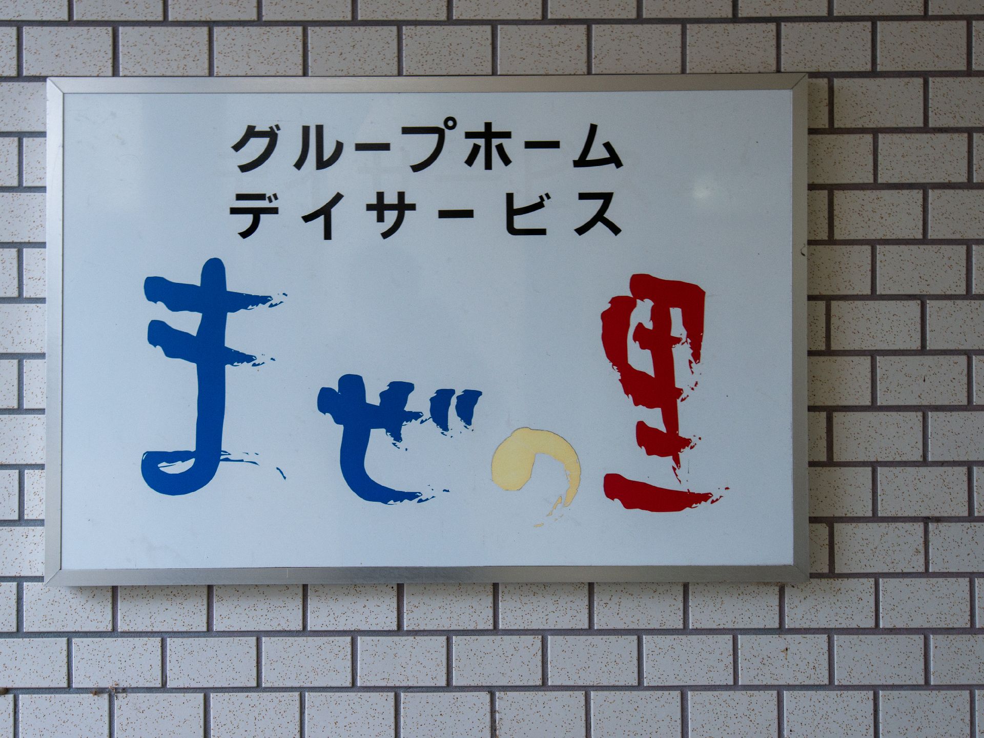ベージュのソファを囲んで楽しそうに話している高齢女性たちの輪の中には白衣を着た女性スタッフもいる。