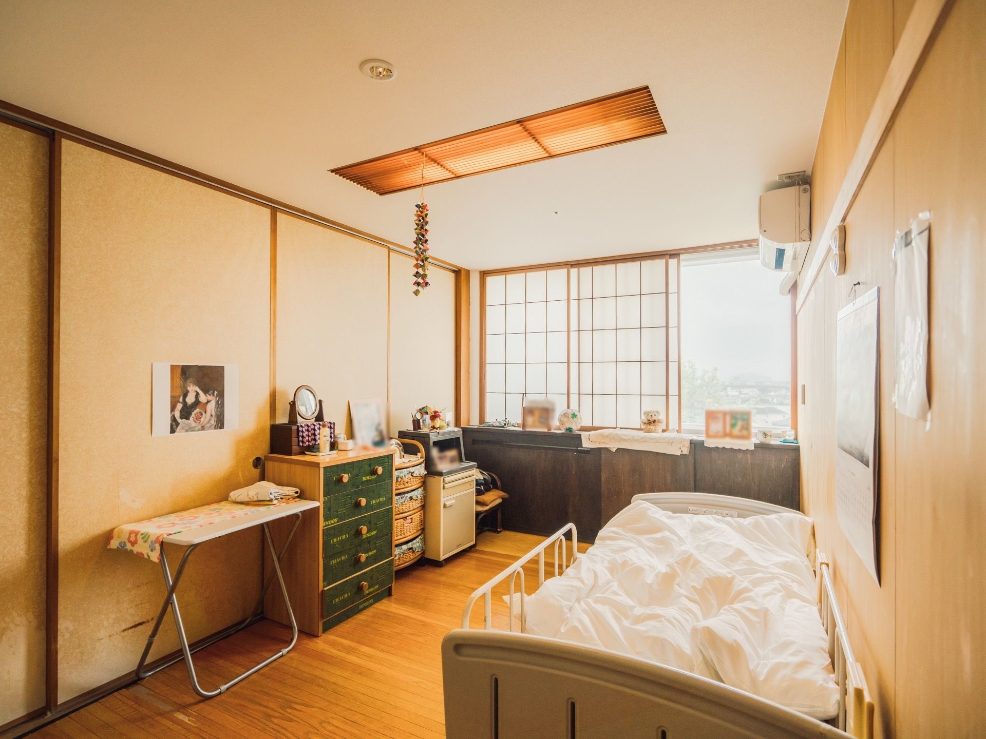落ち着いた和の雰囲気が漂う居室である。エアコンや介護ベッドが完備されており、外を臨める窓が設けられている。