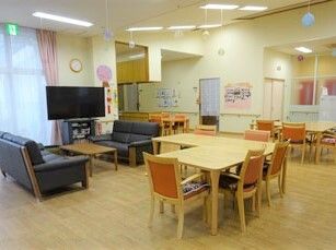 テレビが置いてある施設内のリビングスペース。ソファやいす、テーブルが置いてある