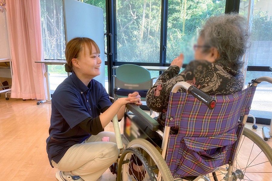 窓辺で会話するスタッフと利用者