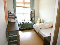 フローリングの居室にはベッドやこたつ、タンスなどが置かれ、日当たりもよい。