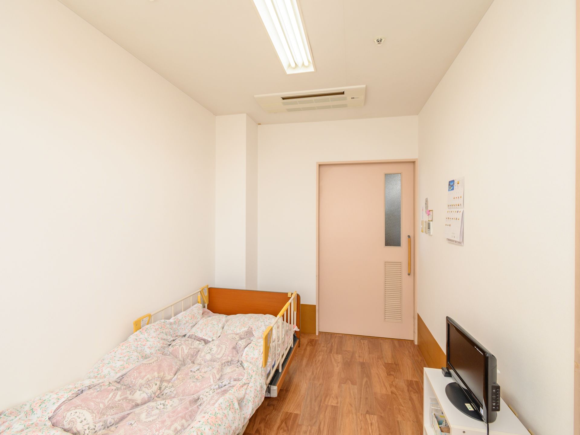介護ベッドが置かれ、テレビが設置されている夫婦2人用の居室