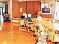 ダイニングテーブルには数名の入居者が座っていて、テレビが付いている。