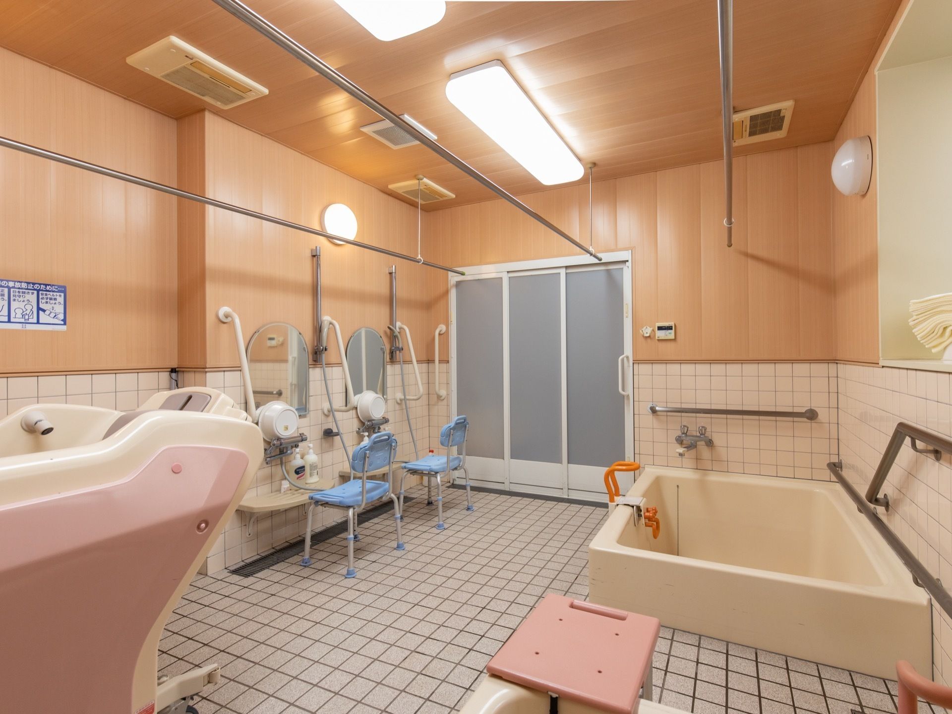 明るく広々とした浴室である。個浴槽と介護浴槽が完備されており、複数の洗い場が設けられている。壁には、手すりが取りつけられている。