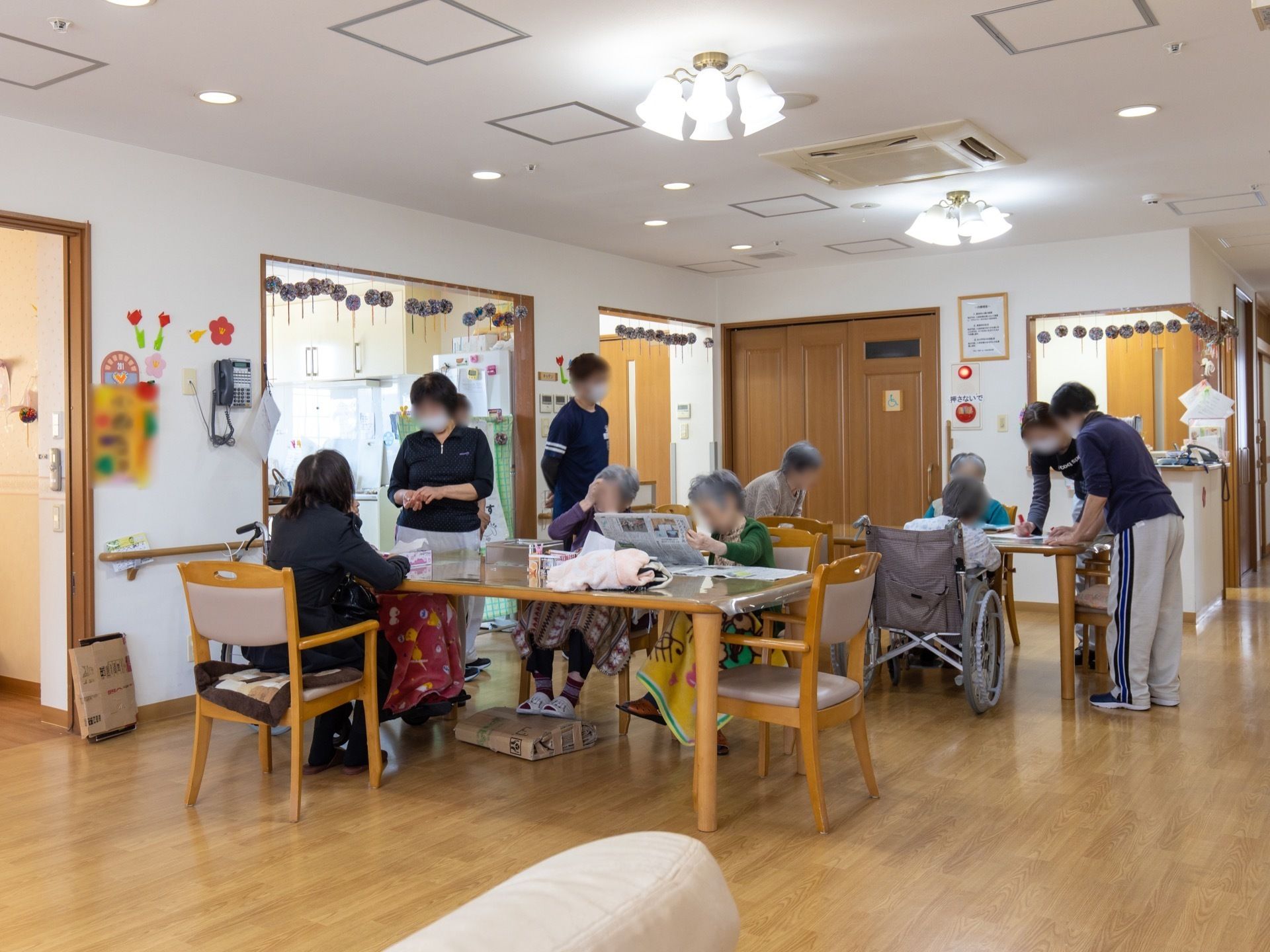 明るく開放的な食堂である。ダイニングテーブルと椅子が置かれている。左側には、キッチンが設けられている。
