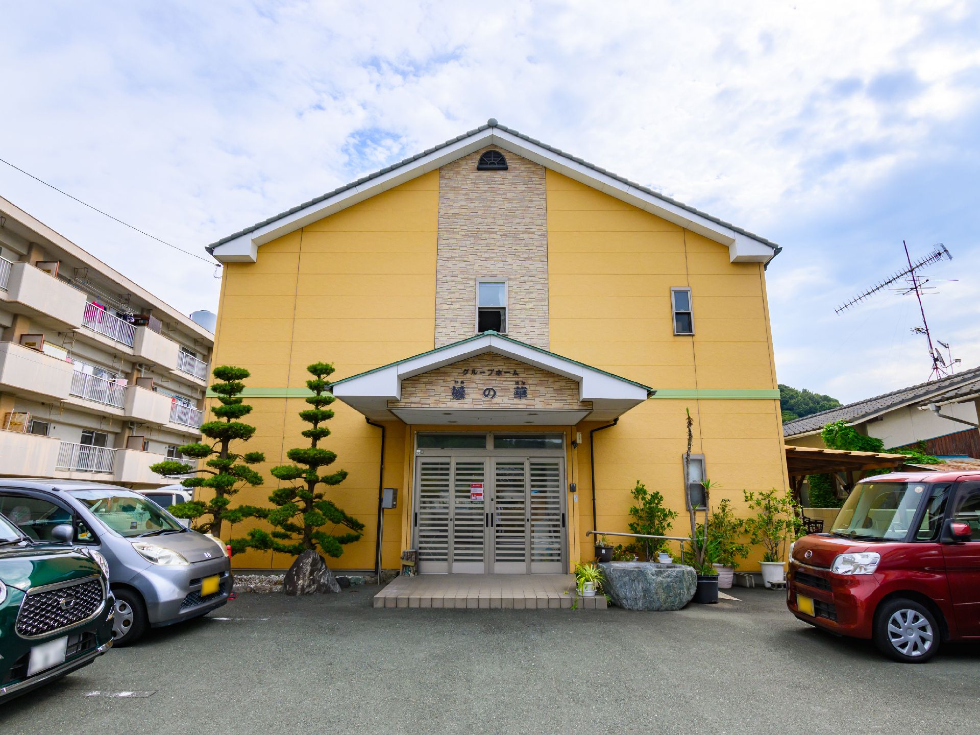 黄色を基調とした２階建てのグループホーム