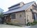 天窓が付いた平屋建ての建物。玄関先には手すり付きのスロープが設置されている。
