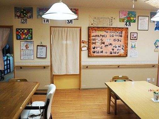 たくさんの作品や写真が飾られた共有スペースにはデザインの異なるダイニングテーブルセットが置かれている。
