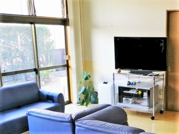 テレビが置いてある家庭のリビングのようなリラックススペース。施設内の共有スペースの写真