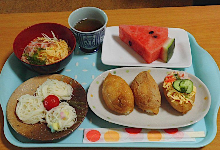 器に丸く盛られたそうめんと、ちらしいなり、スイカの付いた特別食