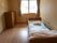 タンスや寝具付きのベッドが置かれたフローリングの部屋には大きな窓が付いている。
