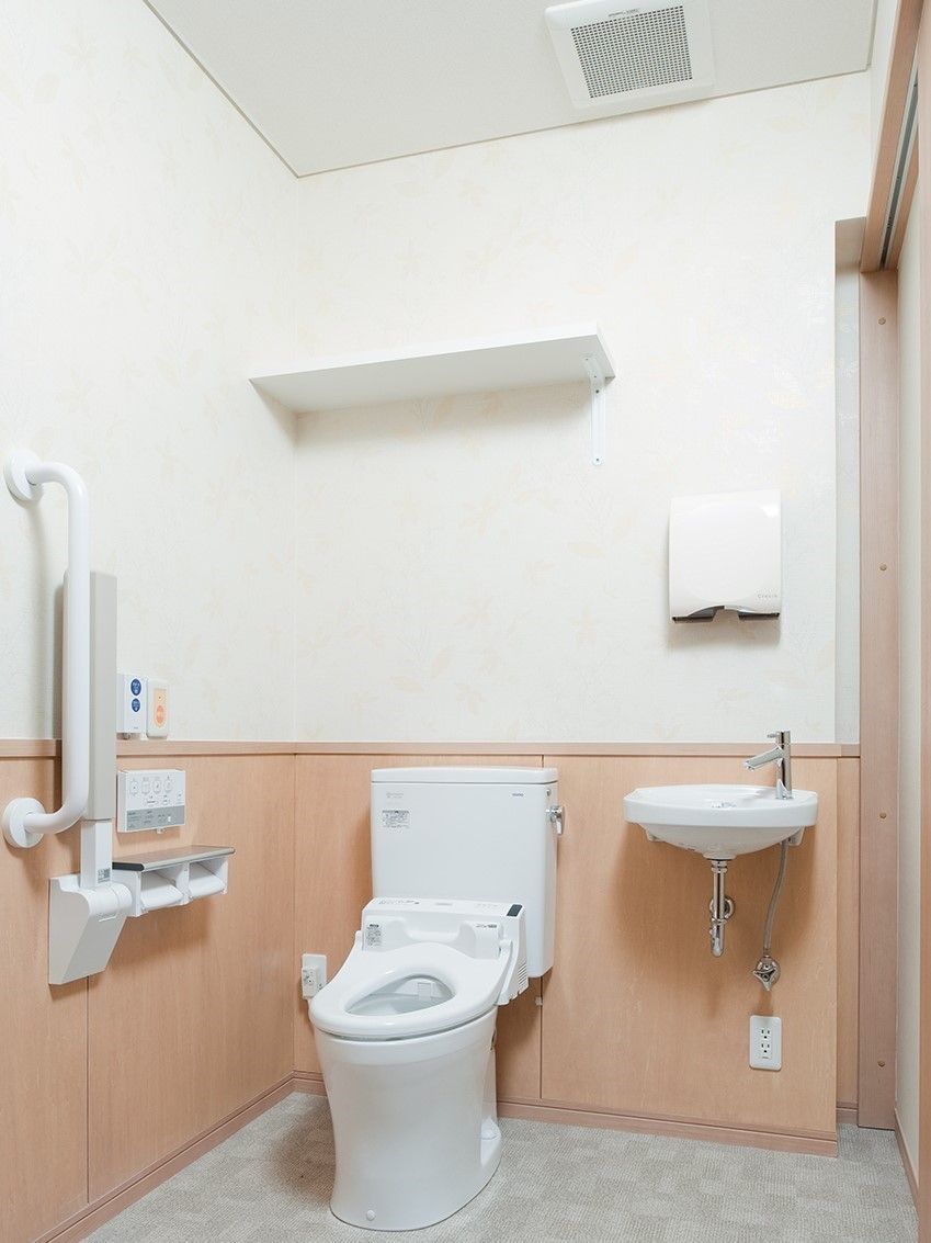 手すりがあるトイレの様子。高齢者用施設にある広めのスペースのトイレ