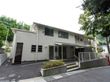 白い外壁の２階建て施設である。螺旋階段が設置されている。建物前の出入り口には、手すり付きの階段が設けられている。