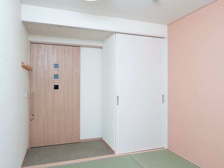 日向ぼっこしながらほほ笑んでいる高齢者男性。リラックスして何かを呼んでいる様子