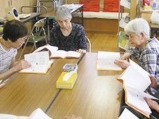施設利用者が集まって何かを呼んでいる様子。施設内のレクリエーション