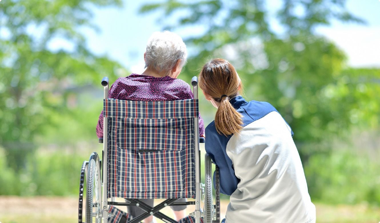 車椅子の方と介助者の後ろ姿