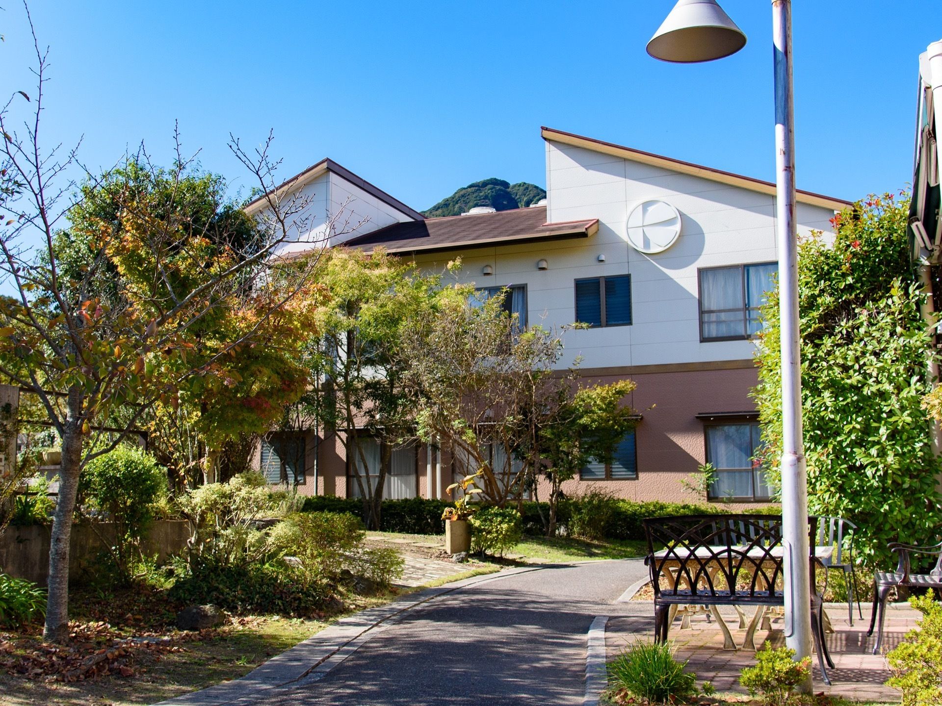 敷地には木々がたくさん植えられており、豊かな自然がある。施設は２階建てになっていて、屋根が特徴的である。