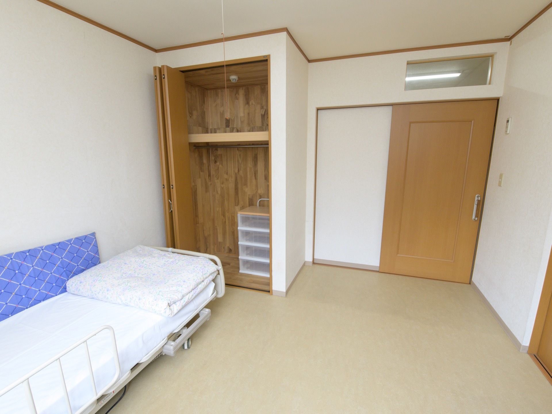 フローリングの居室で、廊下との間はスライド式の扉で仕切られている。クローゼットの中に収納ケースが置かれている。