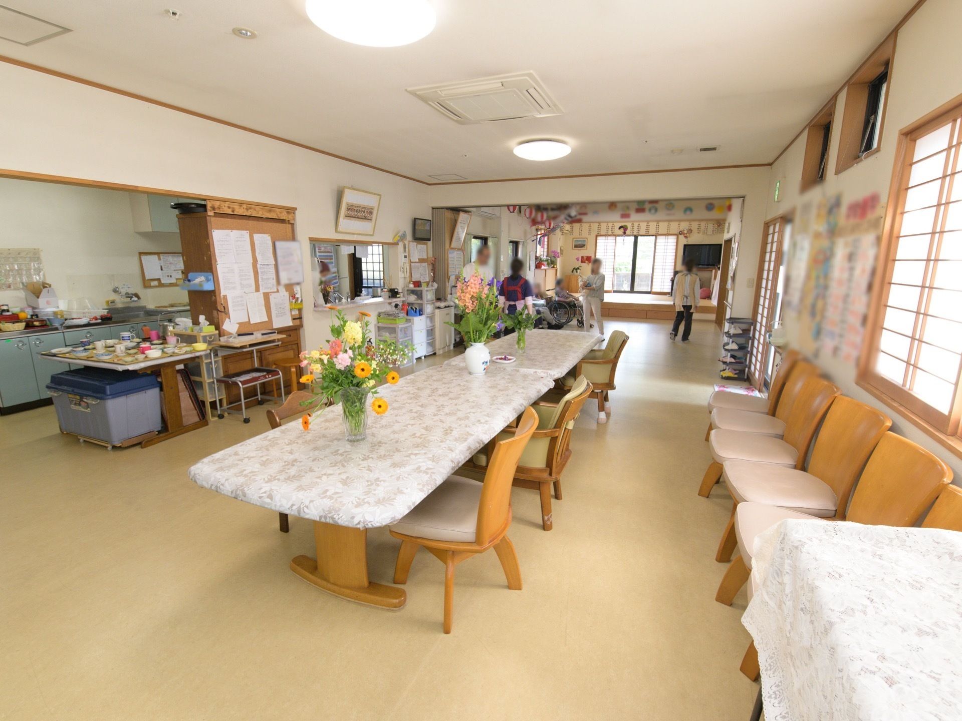台所にお膳が用意されていて、中央に花瓶が並ぶテーブルのある食堂