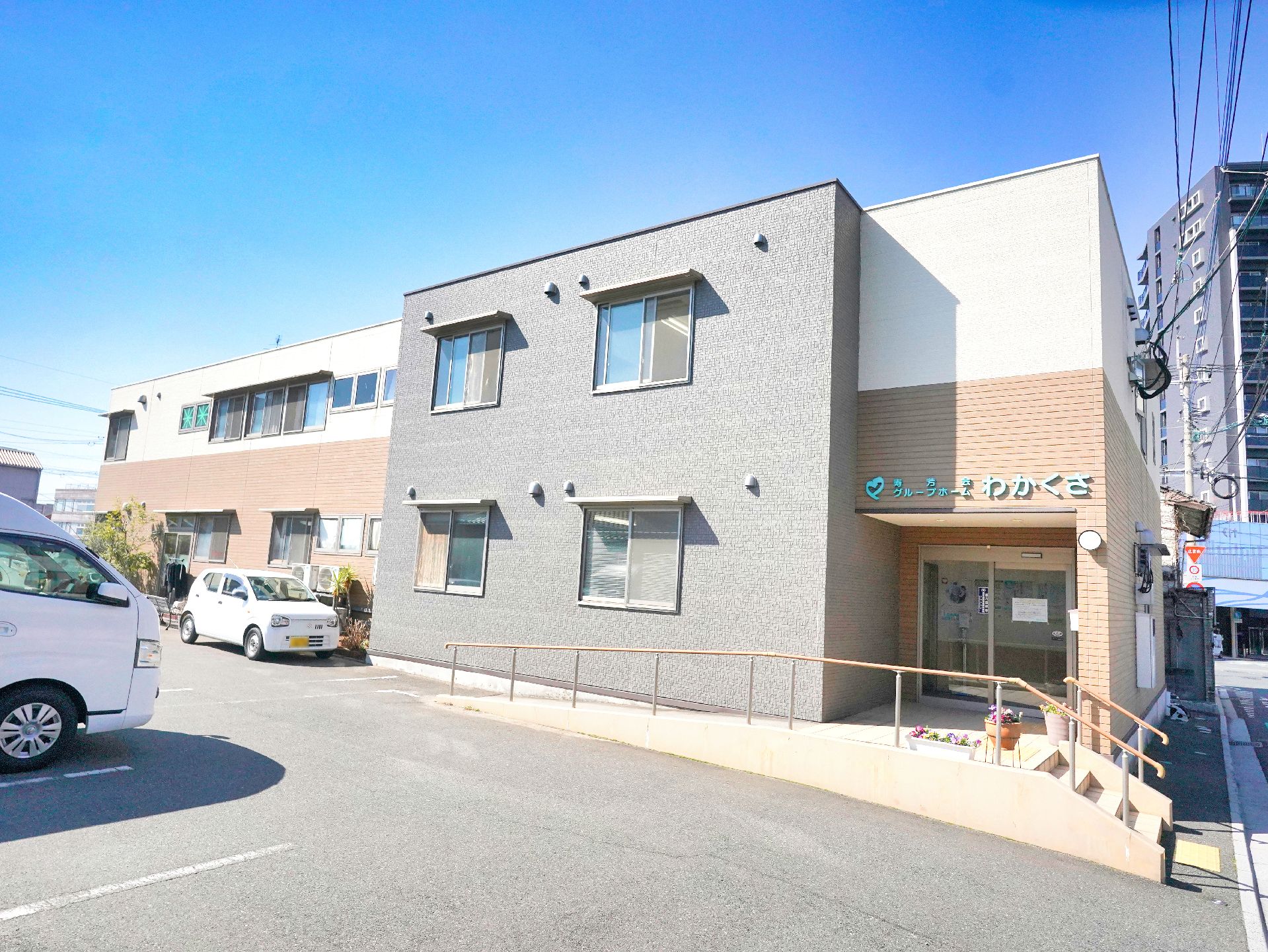 駐車場とスロープが設置してある介護施設の外観