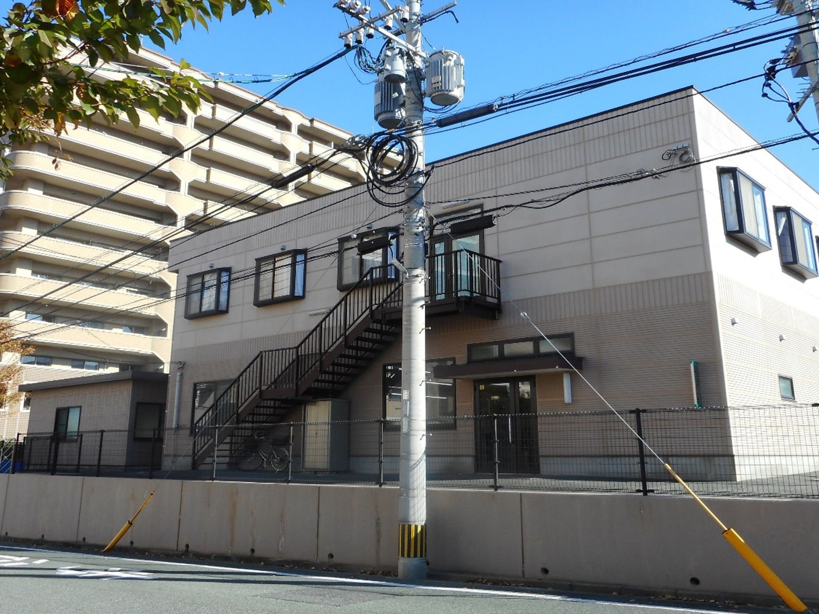 車いすの高齢者と手を握りながら話す介護スタッフの様子。施設内での会話の場面