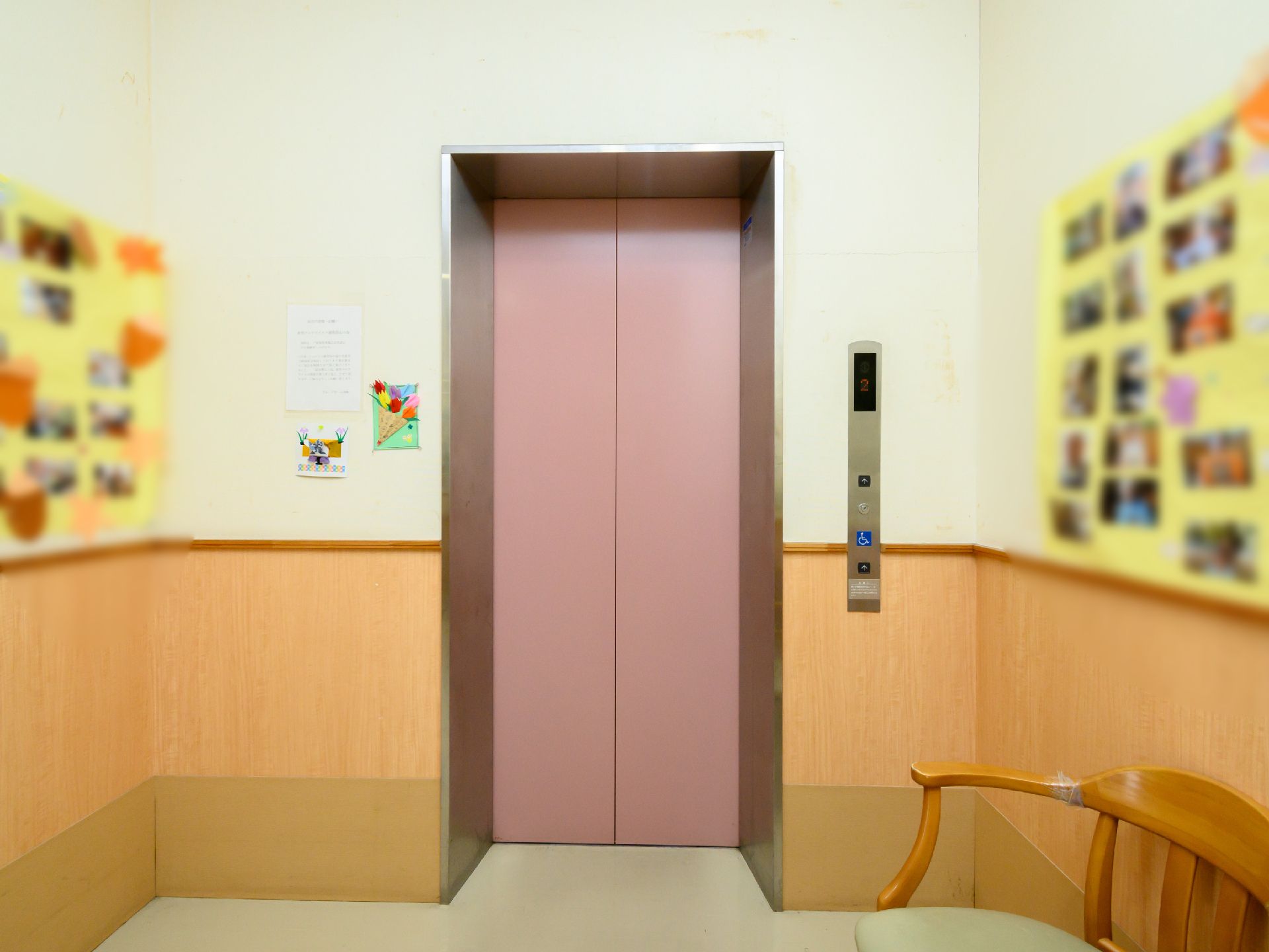 入居者の写真や椅子が設置されているエレベーター前の廊下