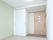 収納付きの広めの部屋が写っている。正面に引き戸の入り口がある