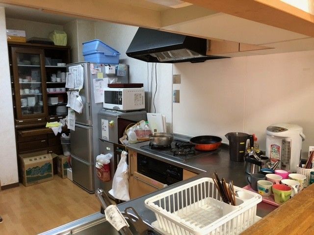 キッチンには鍋やフライパン、コップ、ポッド、電子レンジなど、生活感が溢れている。