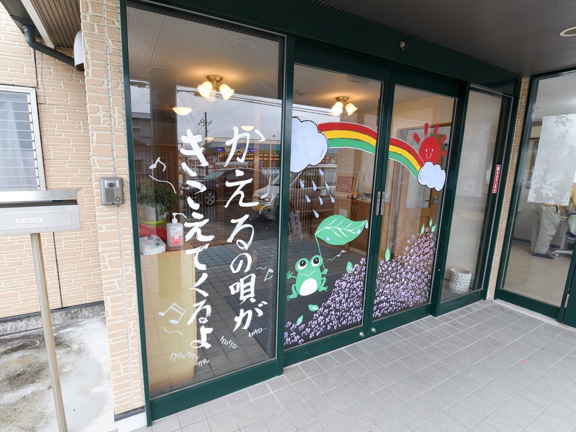 入り口はボタン式の自動ドアになっており、イラストが描いてある。横にはインターホンと郵便受けがついている。