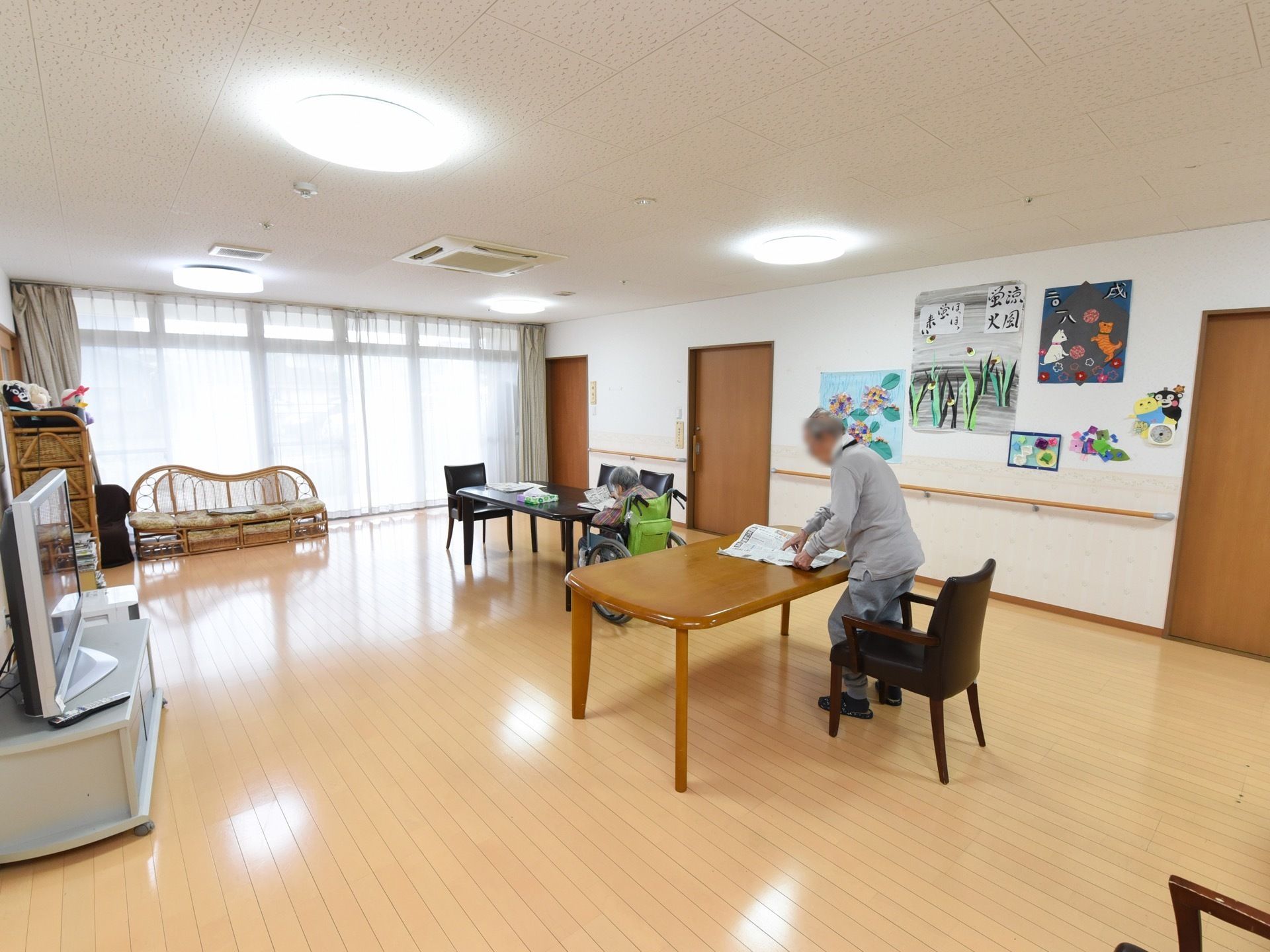 リビングの壁には入居者様の制作物や習字などが飾られている。雑誌や新聞が取り揃えられており、自由に読むことができる。