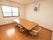 木のあたたかみが感じられる、フローリングの部屋である。広々としたテーブルに、複数の背もたれ椅子が置かれている。