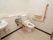 シンプルな手洗い場が備えつけられている広々としたトイレである。便器の両サイドには、手すりが設置されている。
