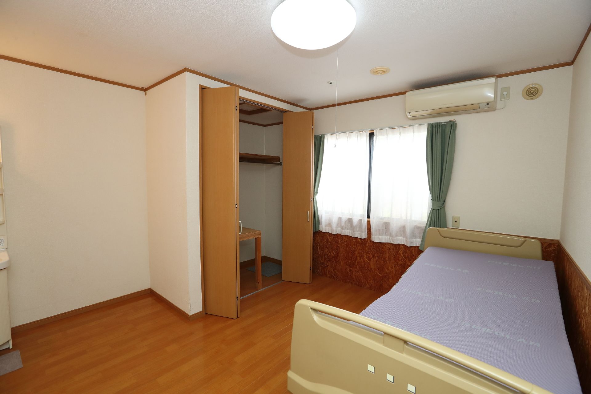 壁際にベッドが置かれた白い壁の部屋