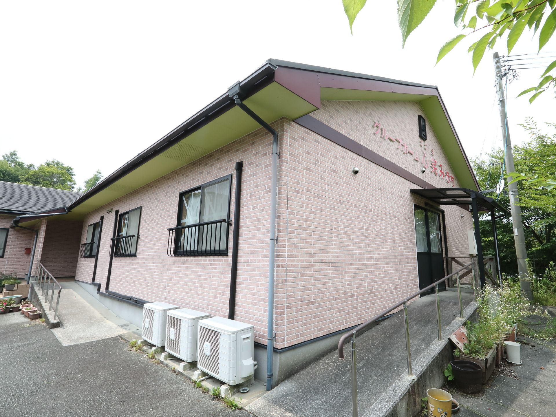 アスファルト沿いに立地しているレンガ調の三角の屋根が付いた建物