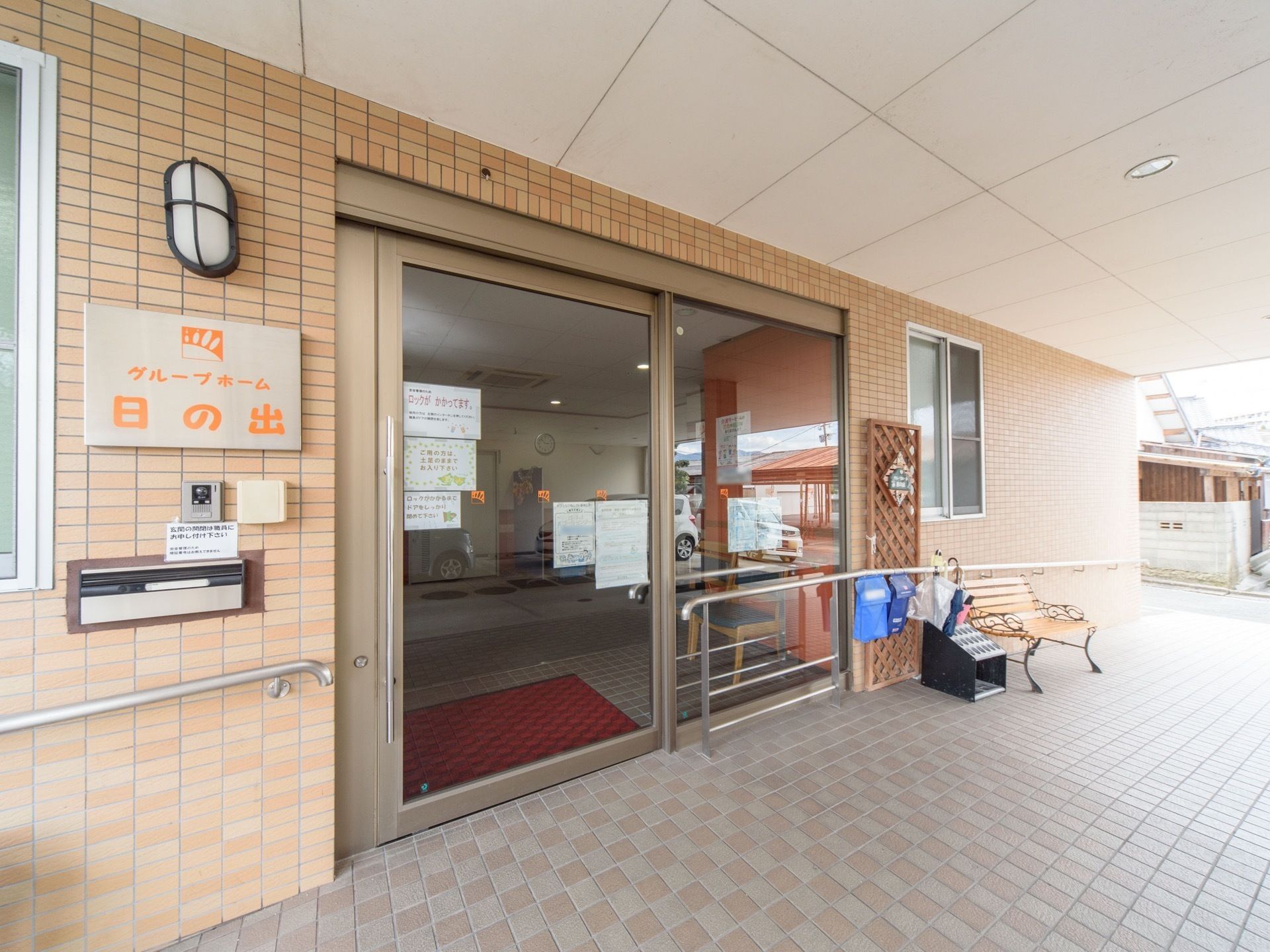 外壁には施設名が記された看板が設置されており、インターホンと郵便ポストが付けられている。入口は自動扉である。