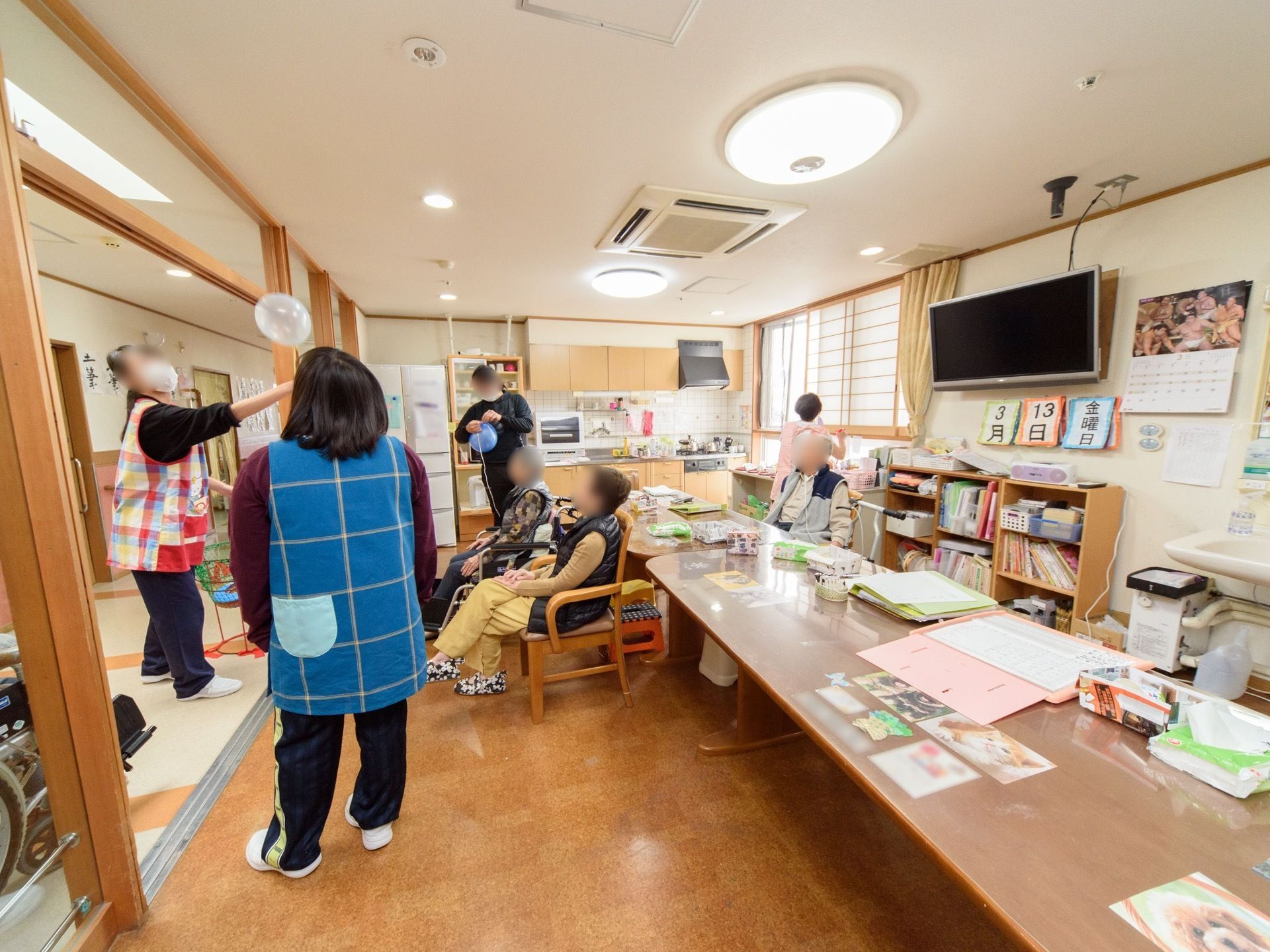 横長のテーブルが置かれた、共有のスペースである。スタッフとともに入居者が、レクリエーションを行っている。