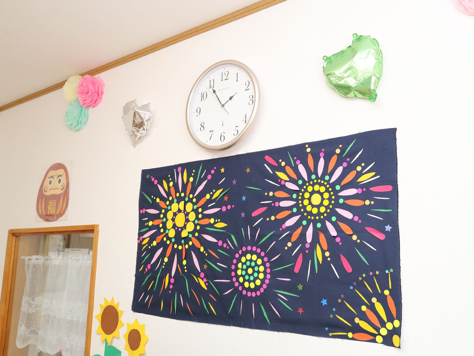 壁の時計の下に飾られた花火が書いてある絵