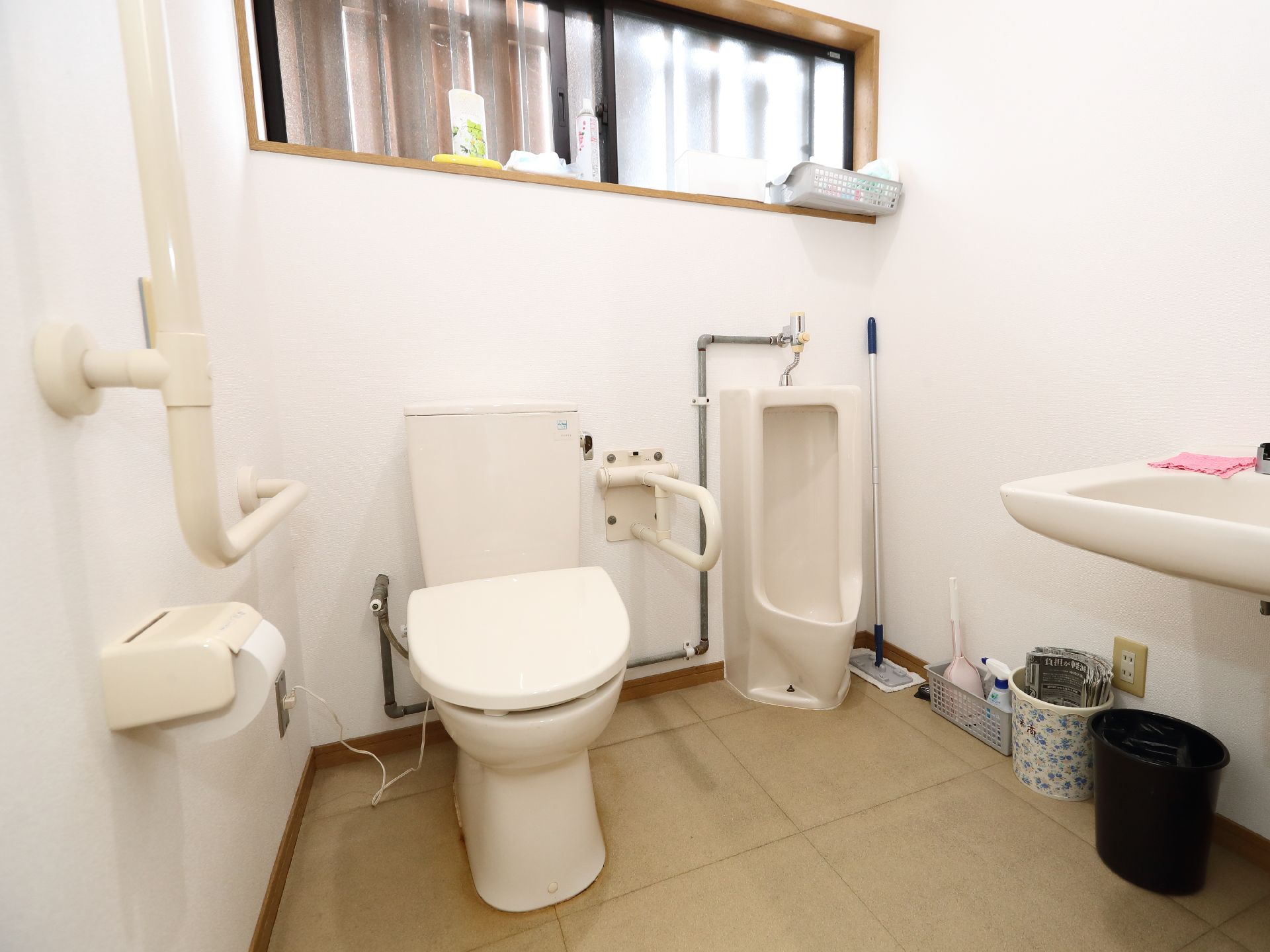 白い壁沿いに配置された洋式便器と小便器