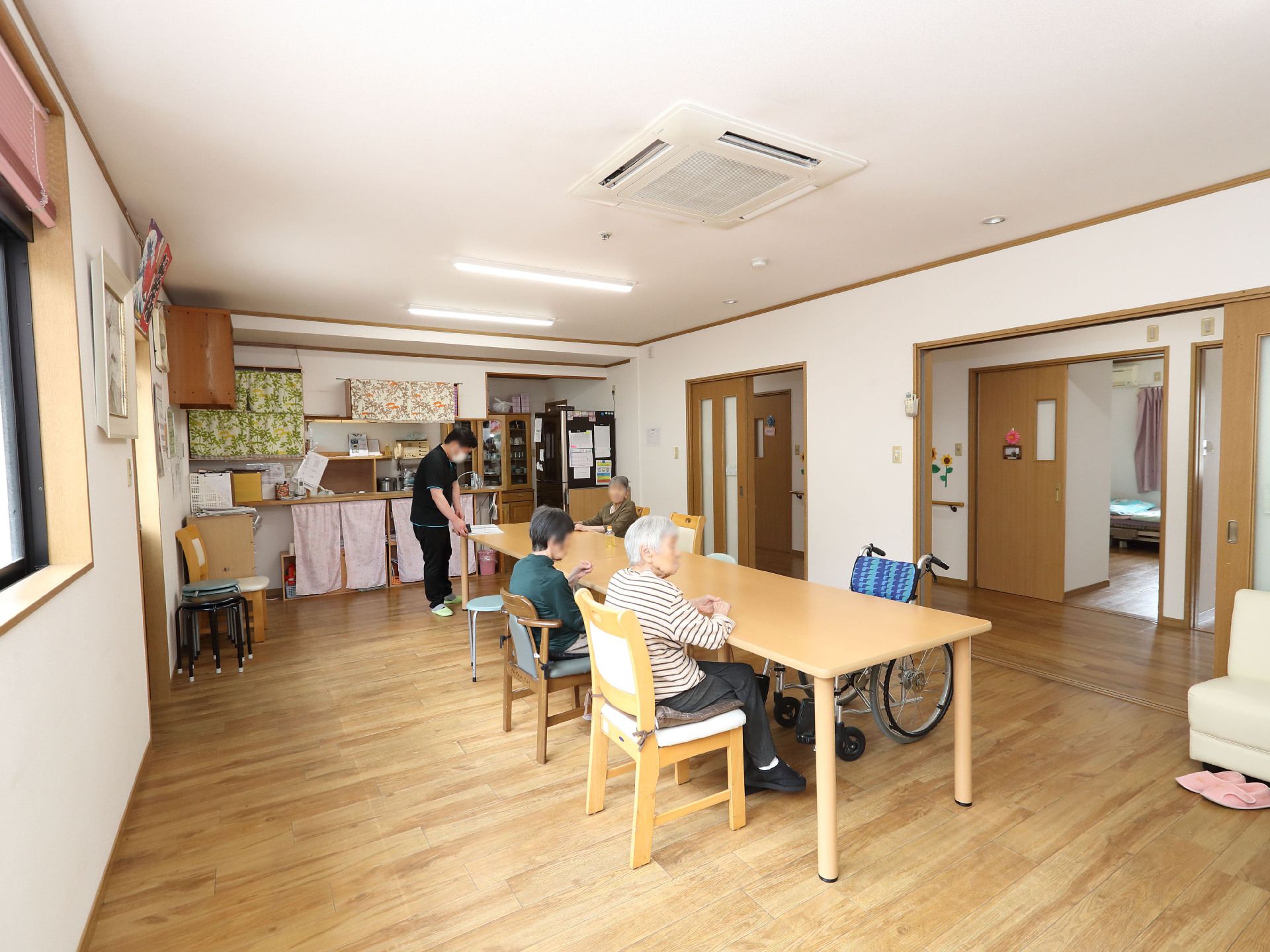 木製の机の周りに座っている入居者様