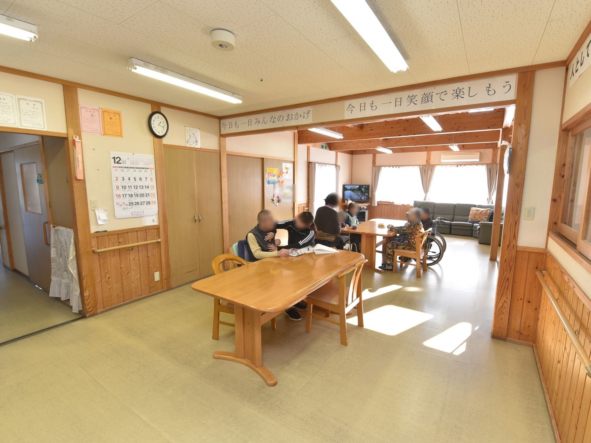 壁半分が木目調の素材を使っている食堂がある。テーブルと椅子が並び、突き当りは大きな窓になっていて外の光が差し込んでいて明るい。
