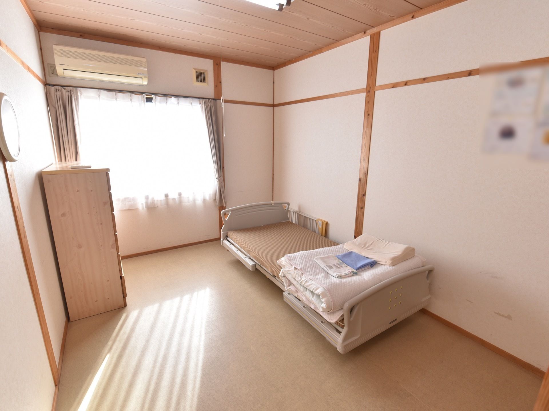 ベッドとタンスを配置したエアコン付きの居室