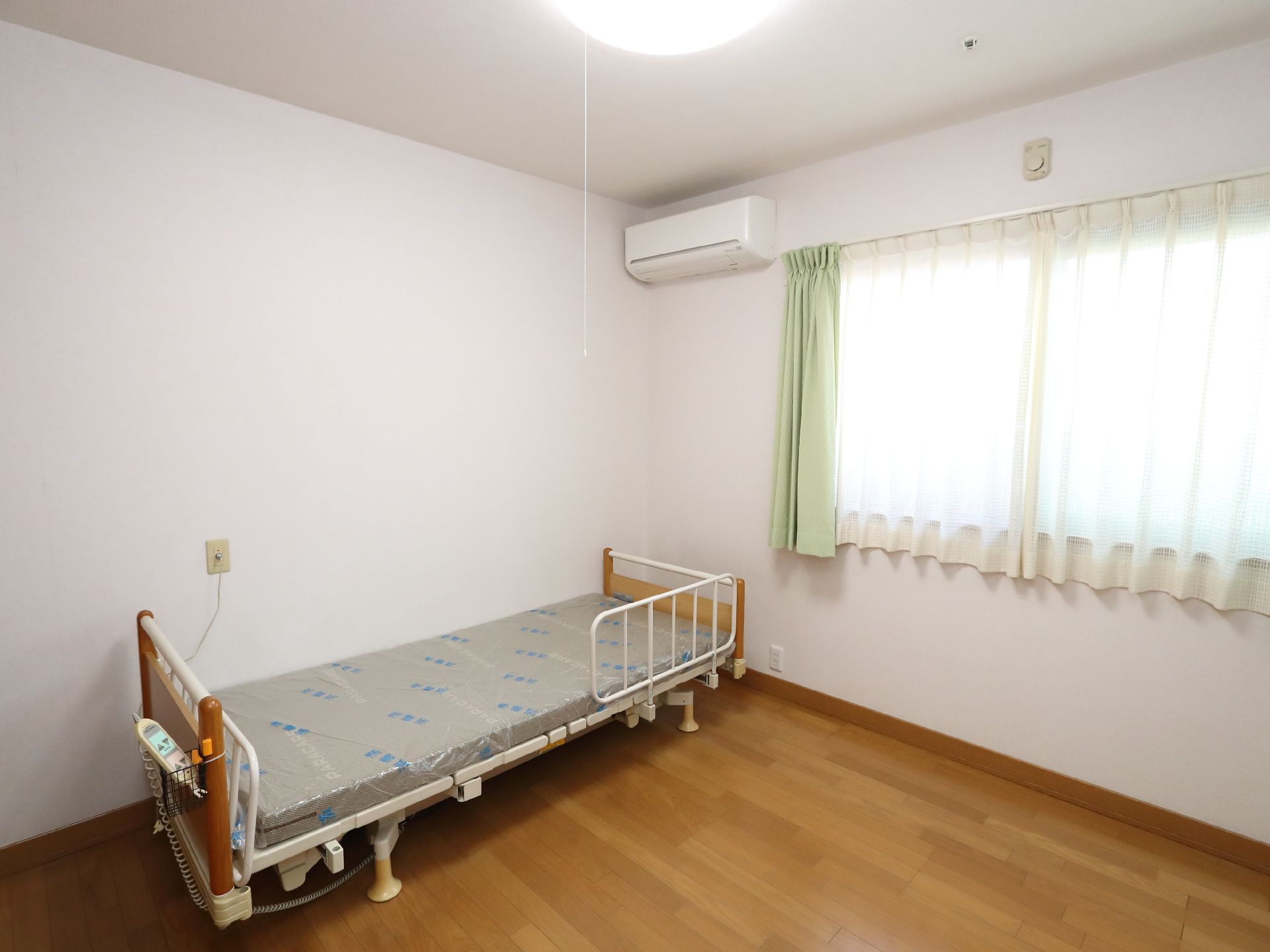 介護ベッドや家具が置かれた、面積の広い居室