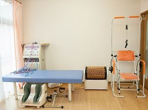 座って足の血行を良くするトレーニング機器などが写っている写真。トレーニングルーム