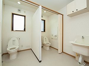 窓のない高齢者用のトイレ。カーテン用のレールのようなものが写っている
