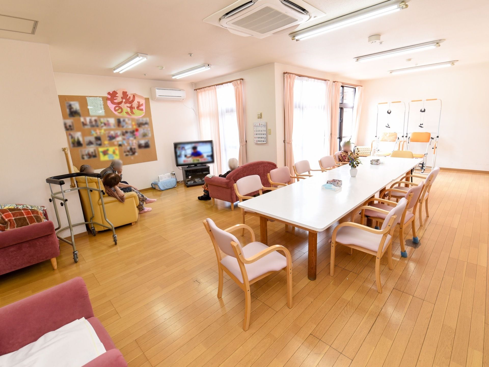 広々としたリビング兼食堂には、ダイニングテーブルやテレビ、ソファが置かれている。右奥には、リハビリスペースが設けられている。